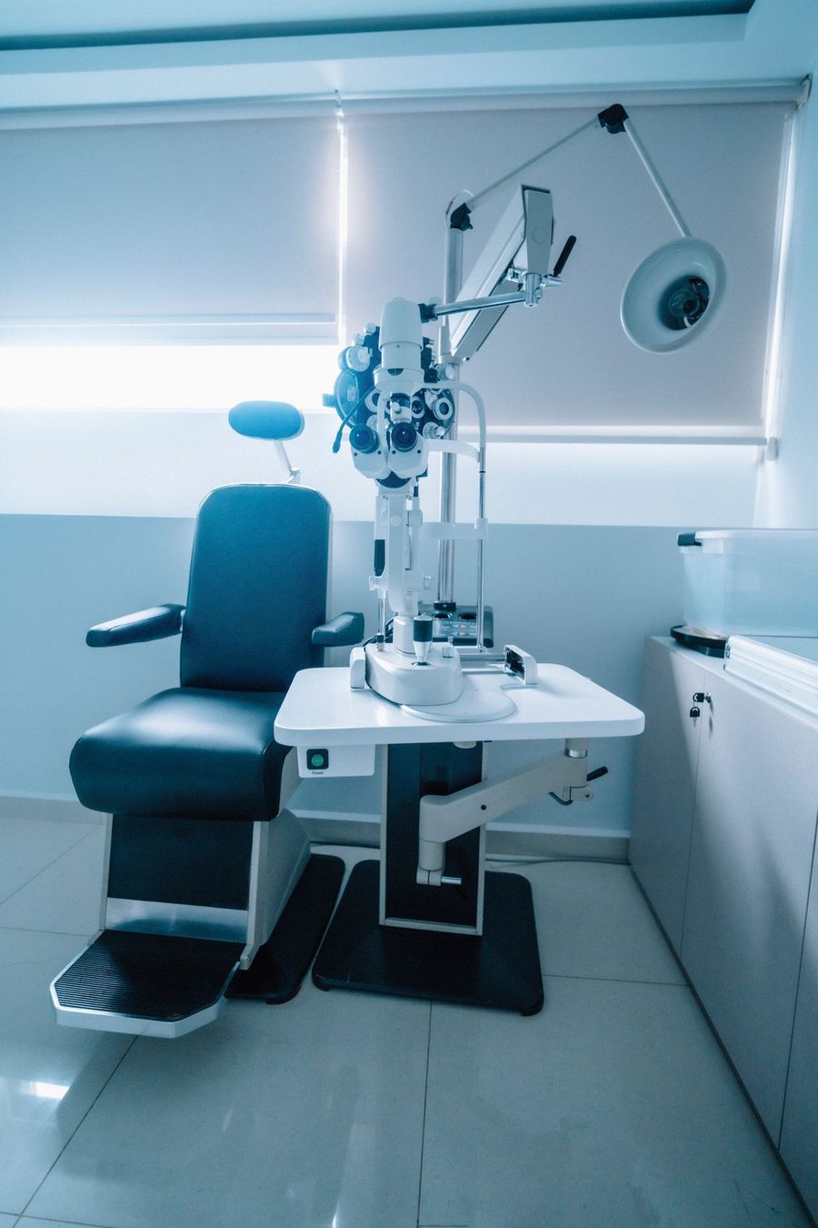 A bright eye examination room with a patient chair and slit lamp (illustrative stock photo)